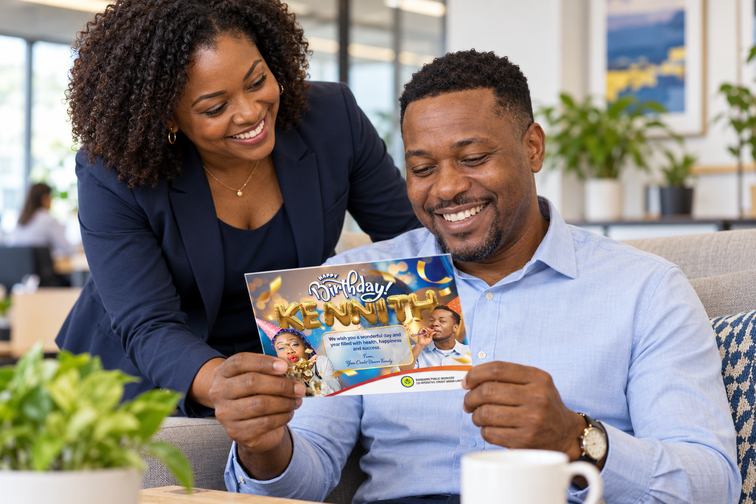A delighted recipient holding a personalised Kenneth birthday card beside a colleague